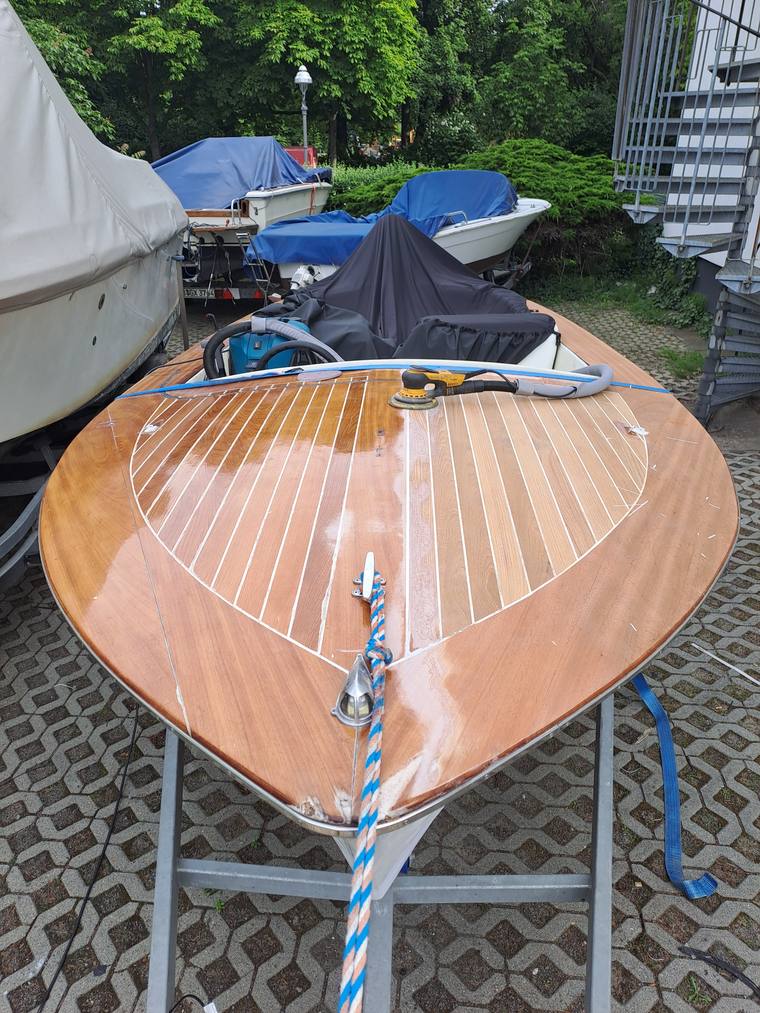 Fertig restauriertes Holzboot mit glänzendem Mahagoni-Rumpf